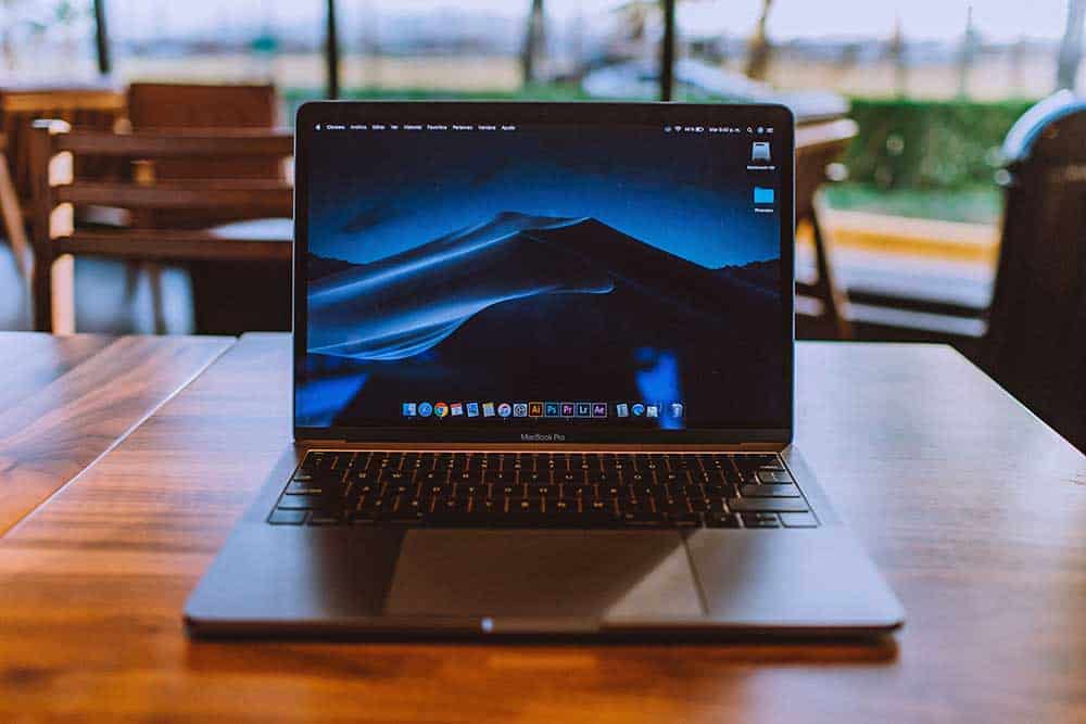 Laptop with digital desert landscape on display, representing modern computer systems and technology.