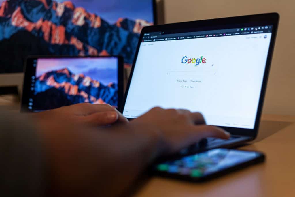 Laptop screen showing Google homepage with search bar.