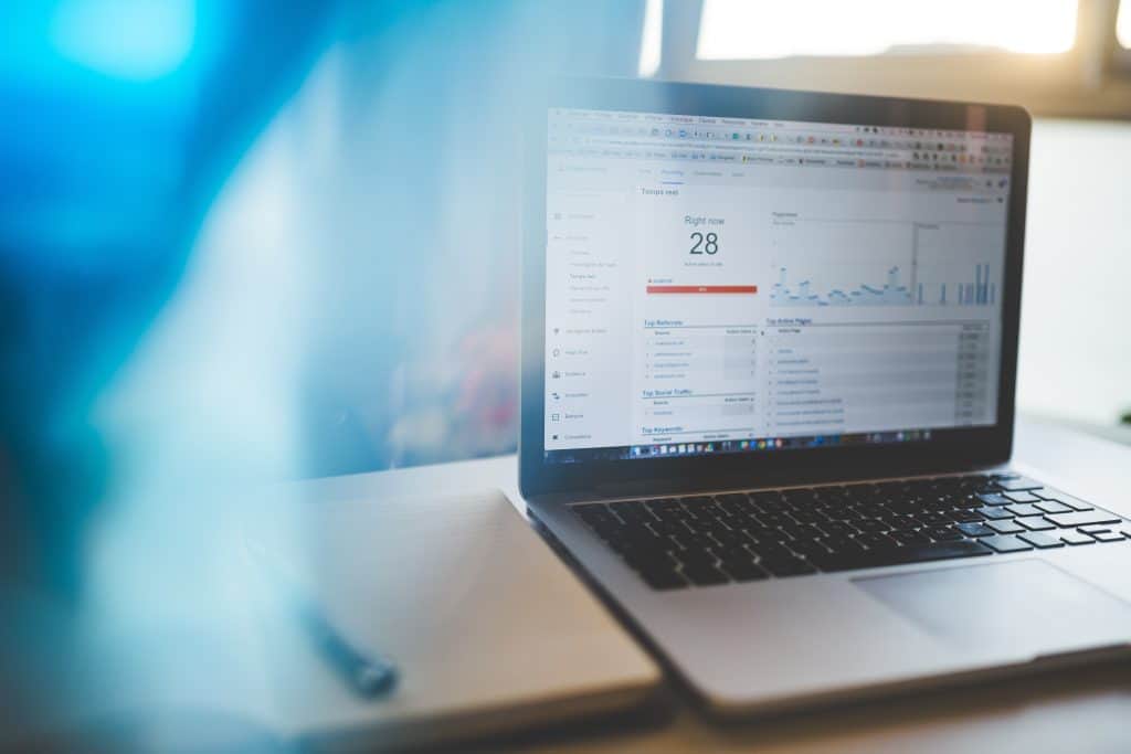 Laptop displaying GA4 analytics dashboard with traffic data and graphs.
