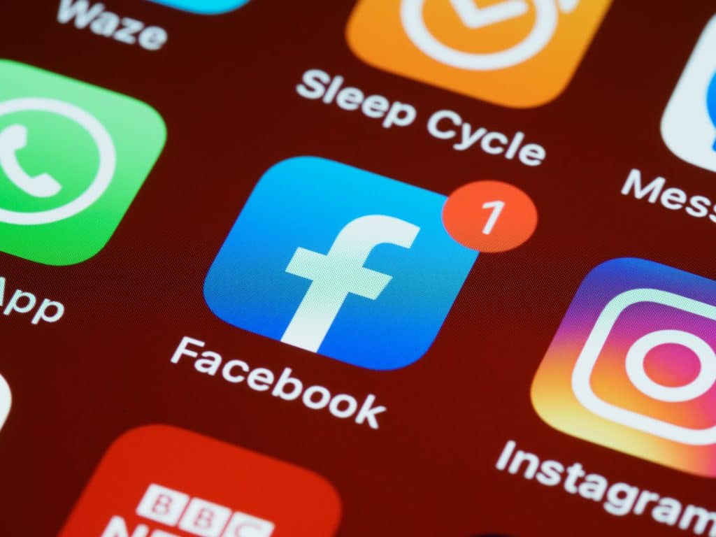 Facebook app icon on smartphone screen highlighting data tracking issues.