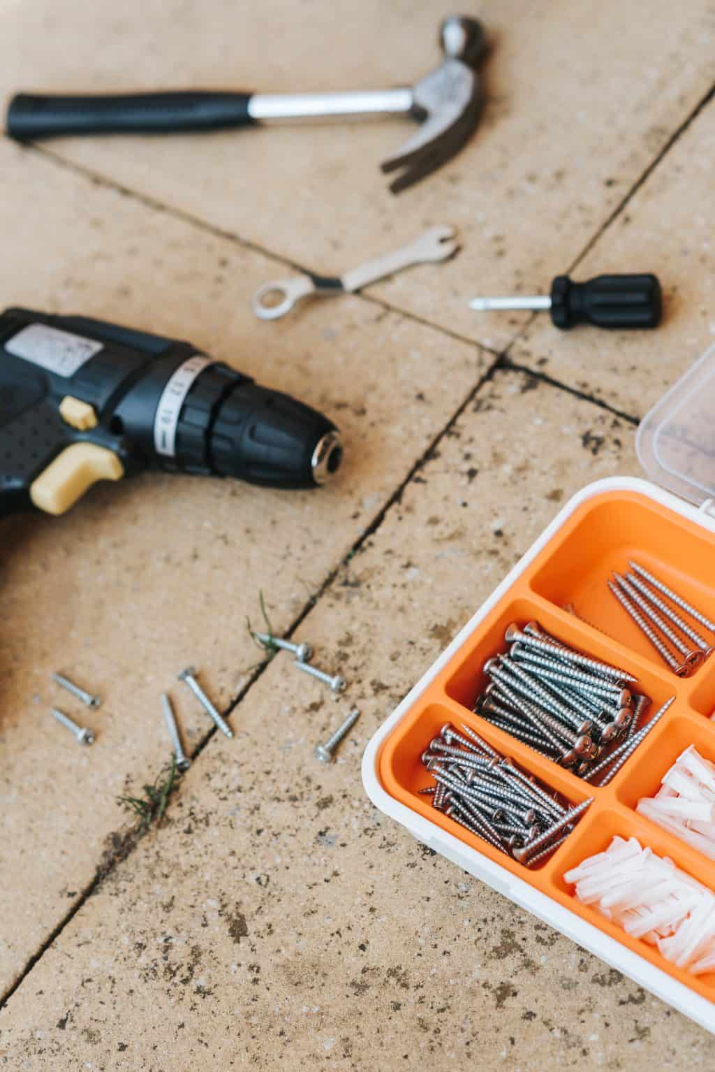 Tools and hardware for fixing stuff at home, including drill, screws, and screwdriver.